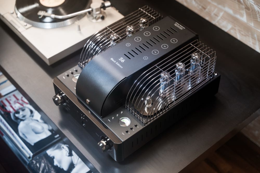Unison S6 Black Edition mit Röhrenschutzgitter neben einem Plattenspieler